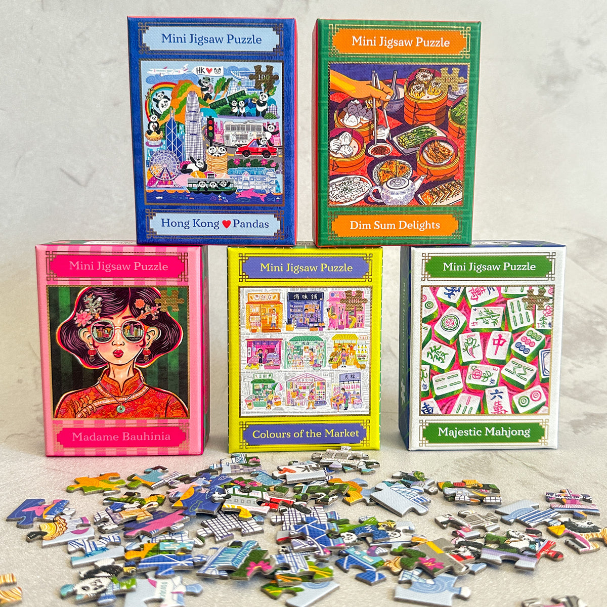 Collection of mini jigsaw puzzles with colorful packaging on a light gray background