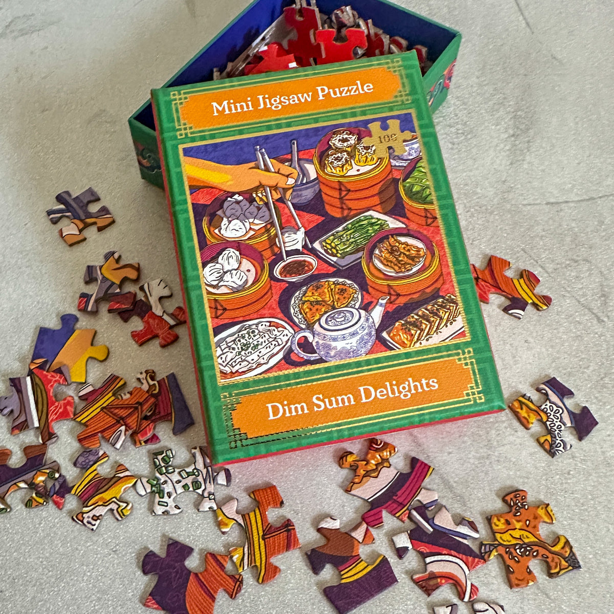 Mini jigsaw puzzle set with 'Dim Sum Delights' theme on a light surface